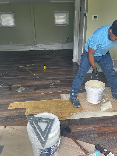 Floor leveling compound being spread over a prepared subfloor before new flooring is installed
